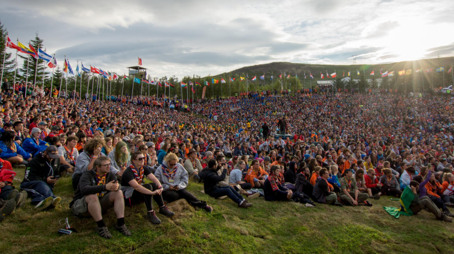 A large meeting of Scouts wearing uniform in an open landscape. 