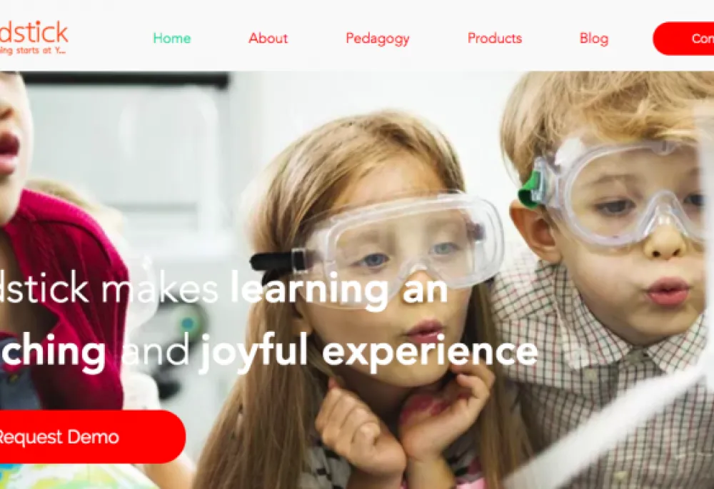 Three children keenly looking at something and yardstick written in red on top left