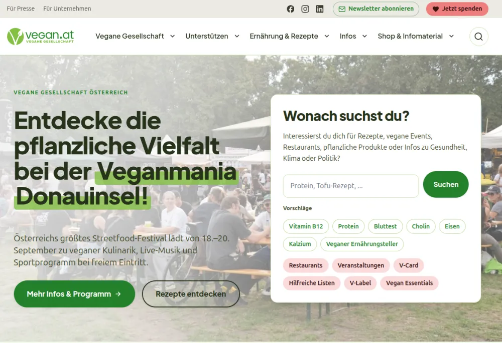 Homepage of vegan.at after the relaunch, desktop viewport: main navigation, hero for the Veganmania Donauinsel festival with a photo of visitors, and a search box "Wonach suchst du?" with suggested topics