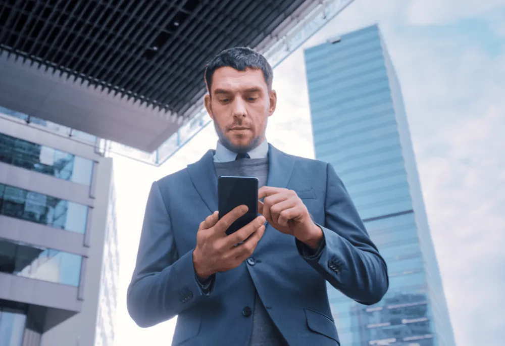 Financial guy scrolling on his phone - TMT - Lemberg Solutions
