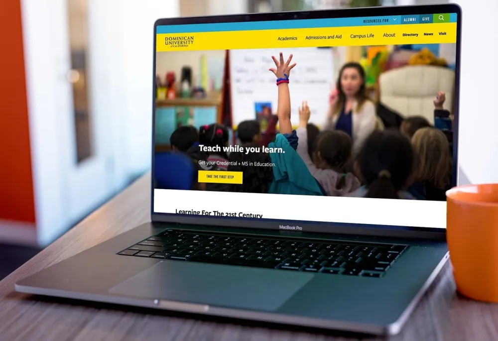 The Dominican University of California homepage displayed on a laptop