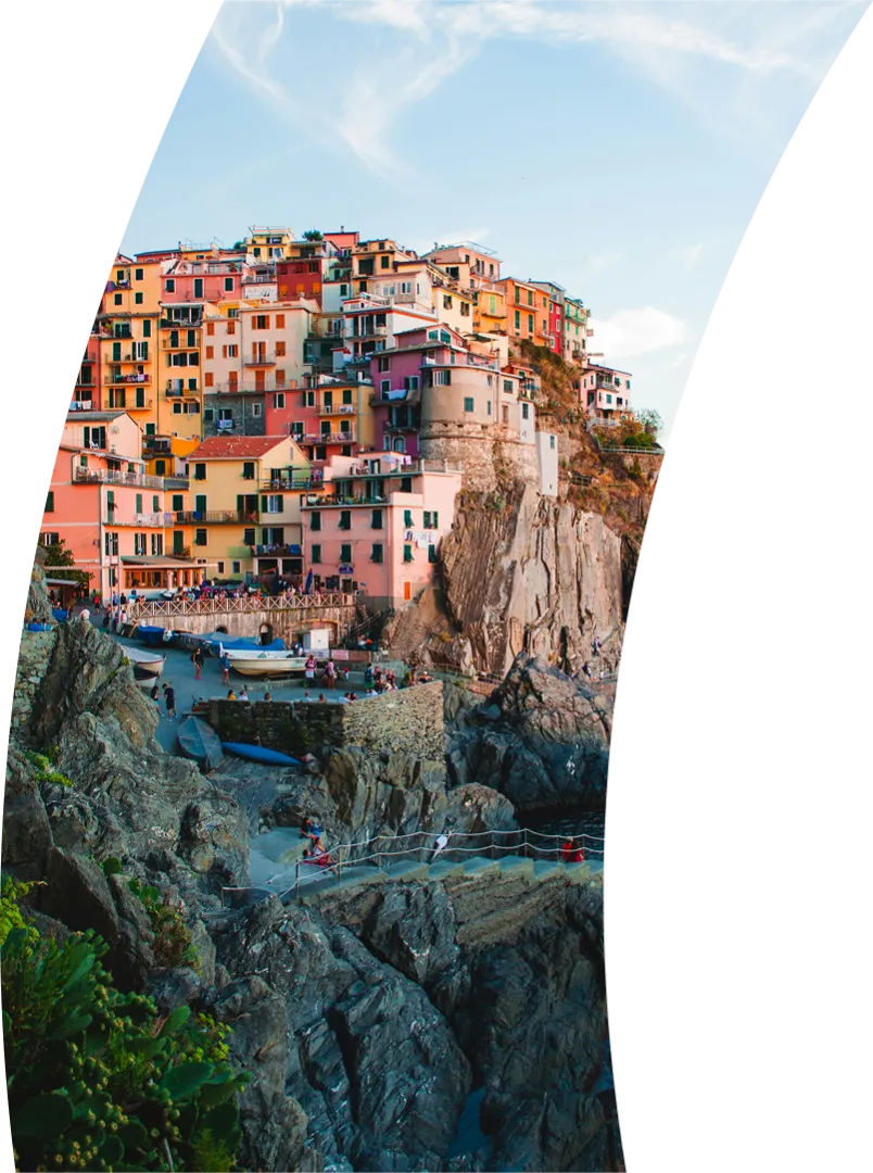 Houses perched on cliff above a beach