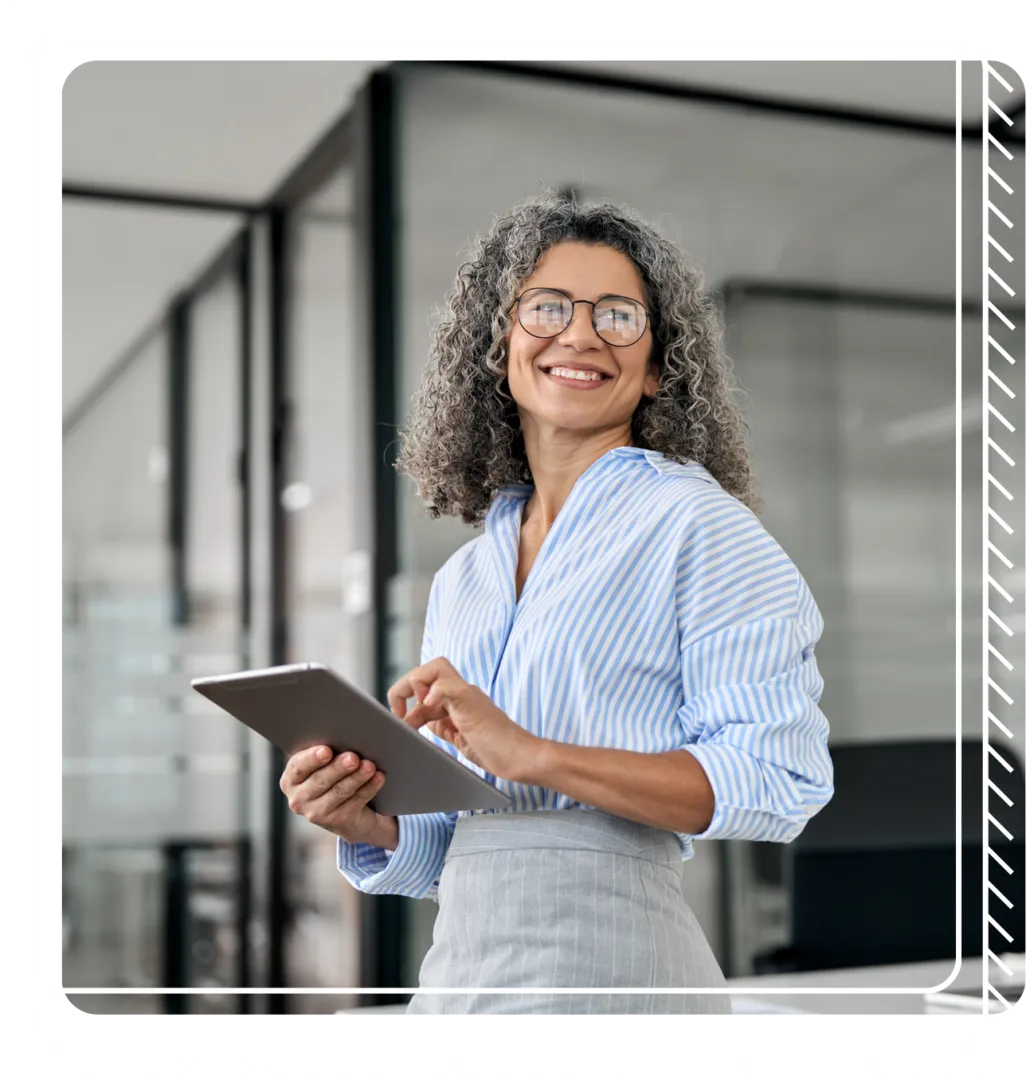 Business woman in office holds tablet and smiles