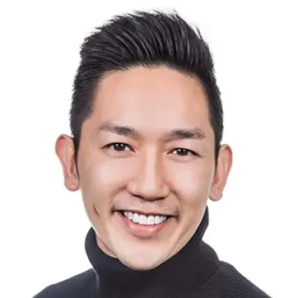 John Tran, Asian man in a turtle neck against a white background. He is smiling.