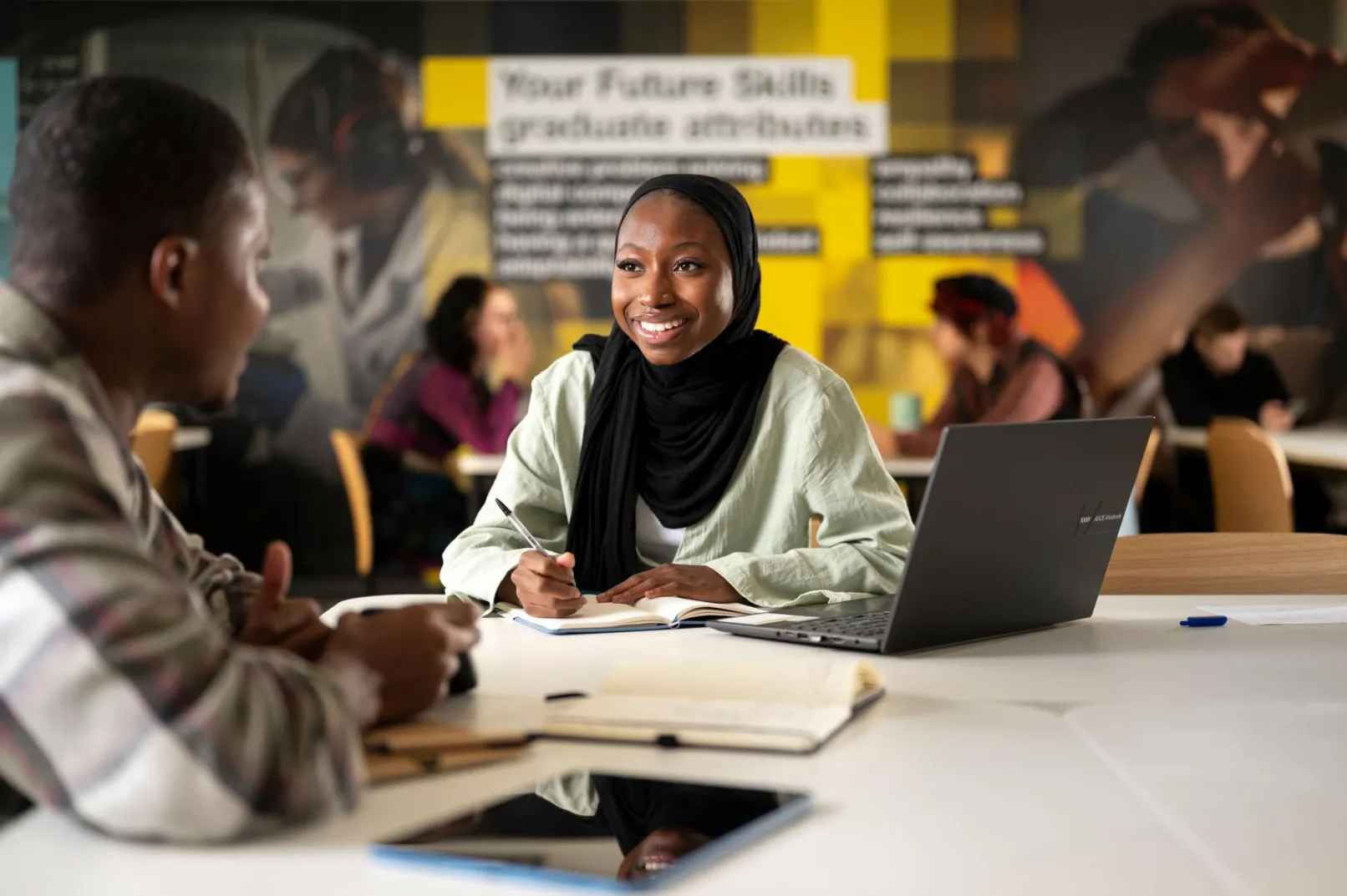 Students talking and studying at a desk