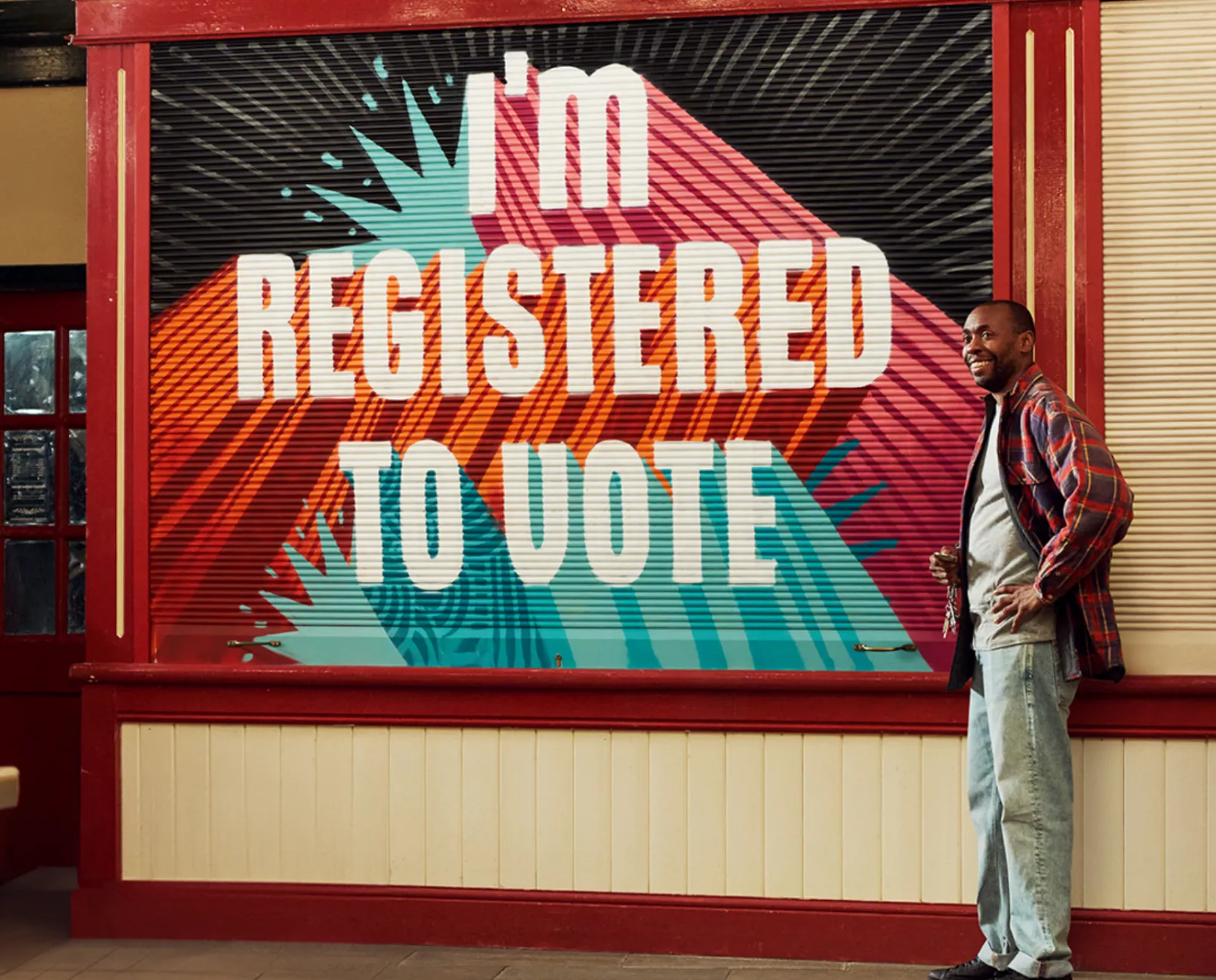 A person stood next to a sign that says 'I'm registered to vote'