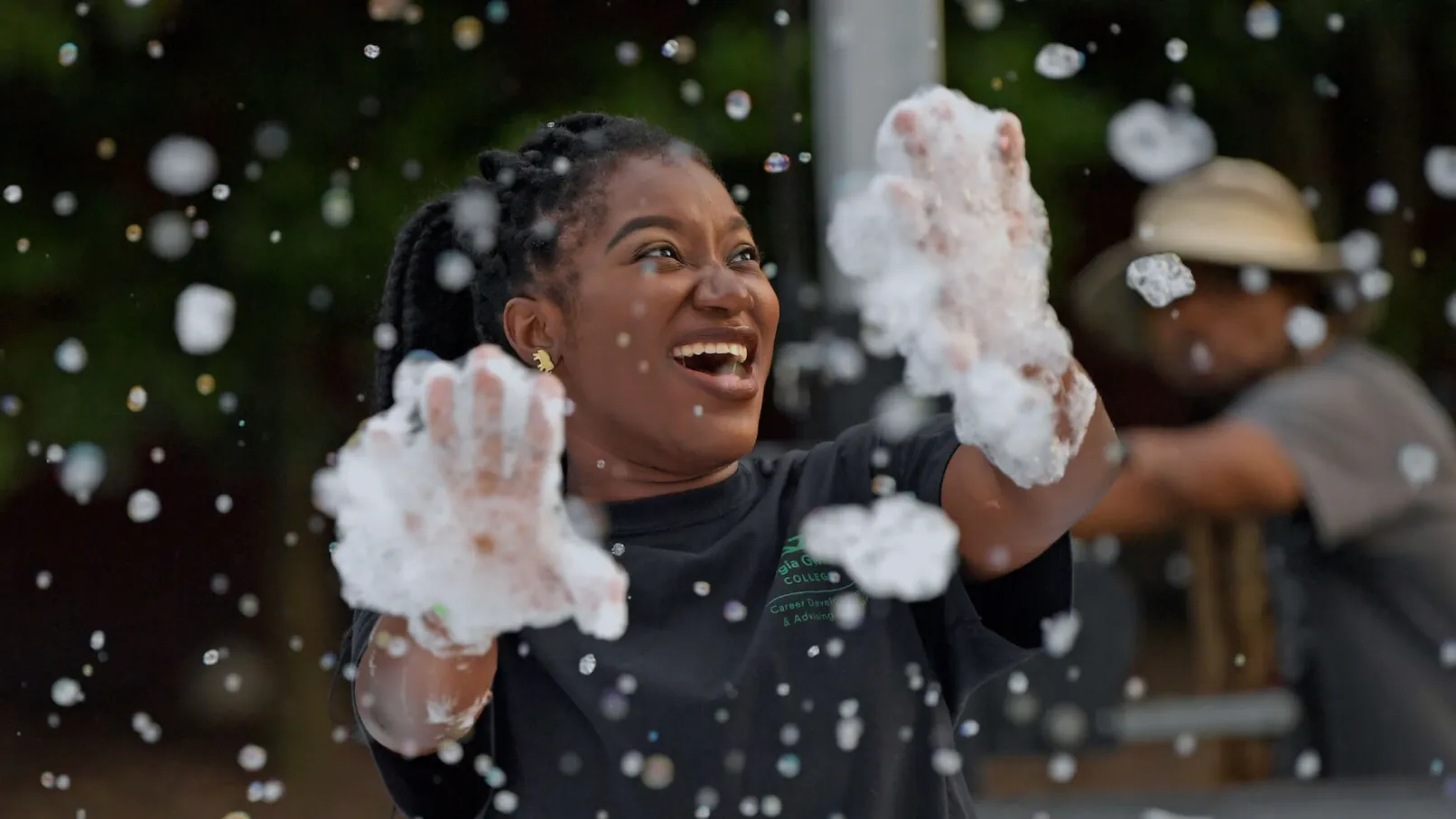Student smiling and playing with foam outdoors, representing campus life at Georgia Gwinnett College.