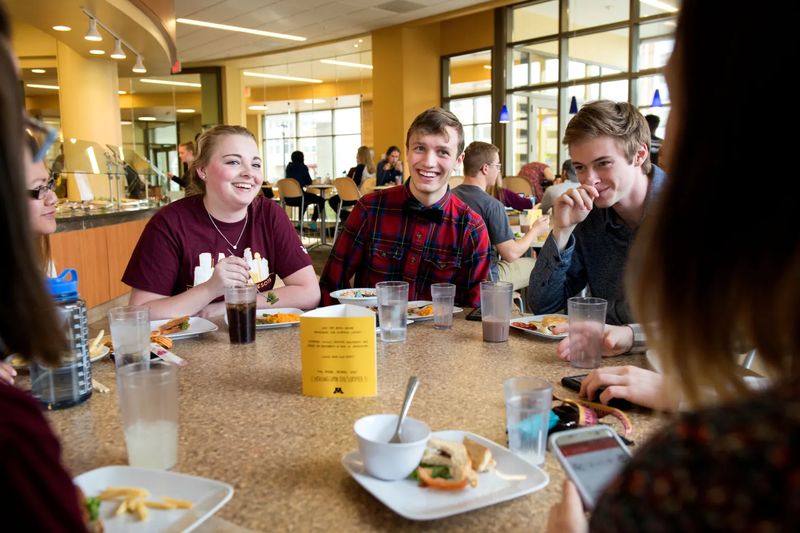 group of college students together at a dorm cafeteria table