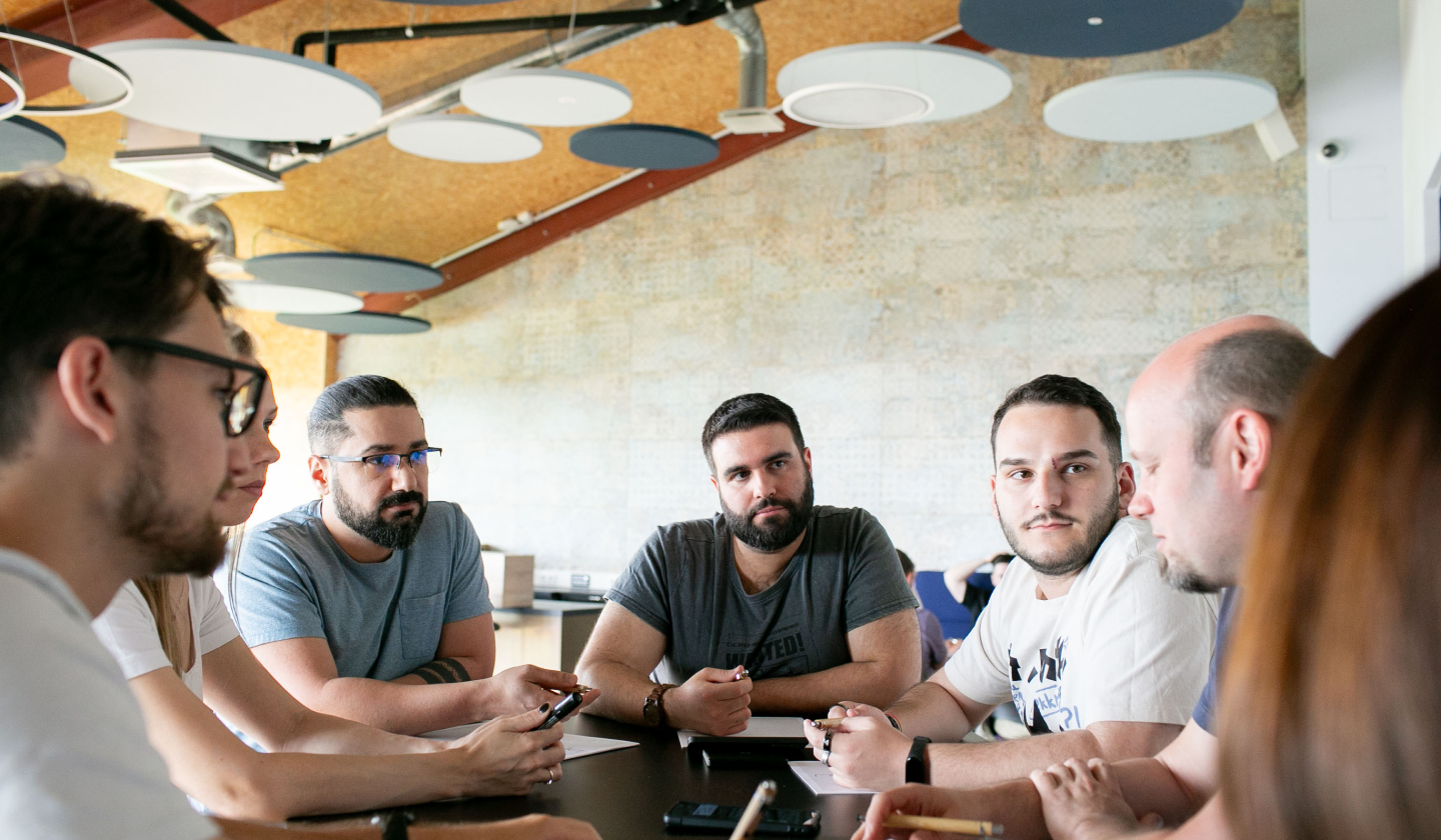 Five people sitting around a table particpating in a workshop discussion. 